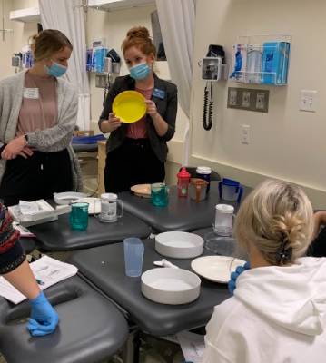 Interprofessional team discussing the rationale behind selecting an appropriate feeding adaptive device to increase feeding independence and swallow safety